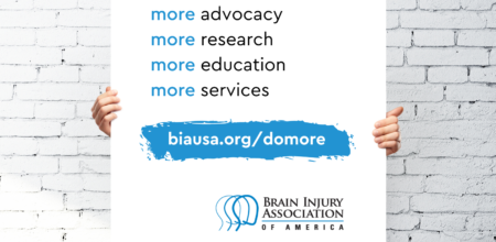 person holding poster that says more advocacy more research more education more services. biausa.org slash donate. BIAA logo bottom right.