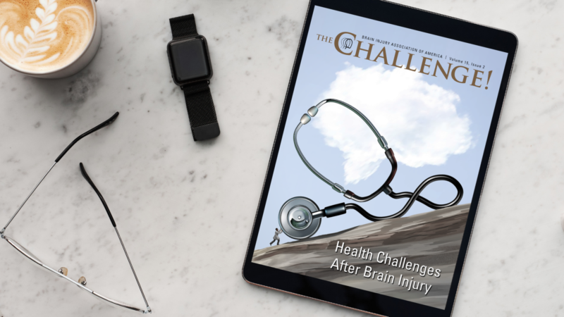 The Challenge Vol. 15 Iss. 2 on Health Challenges displayed on iPad laying on marble table next to cappuccino and glasses.